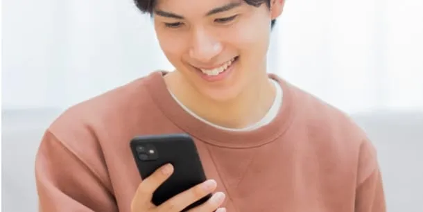 スマホを見て笑顔をうかべる男性