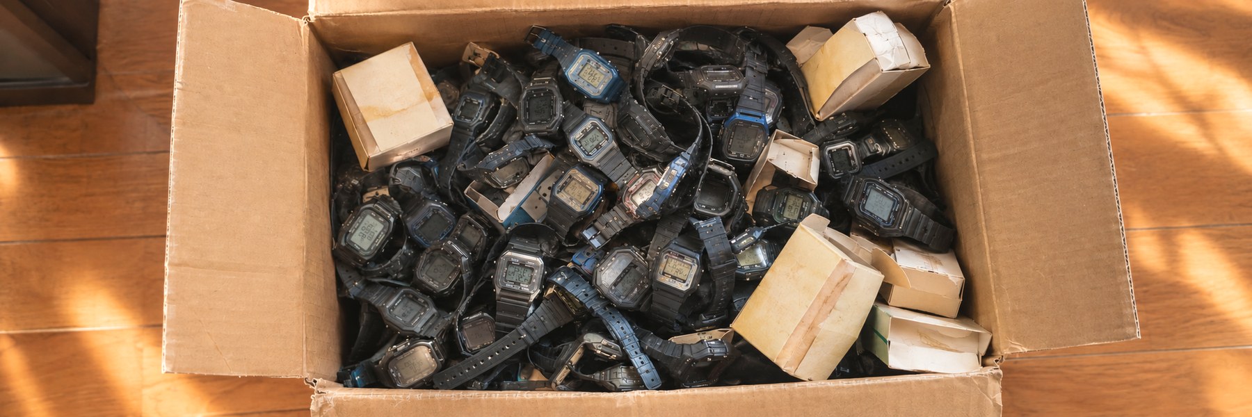 段ボール箱いっぱいに無造作に入った何十本ものG-SHOCKと、日焼けした紙箱